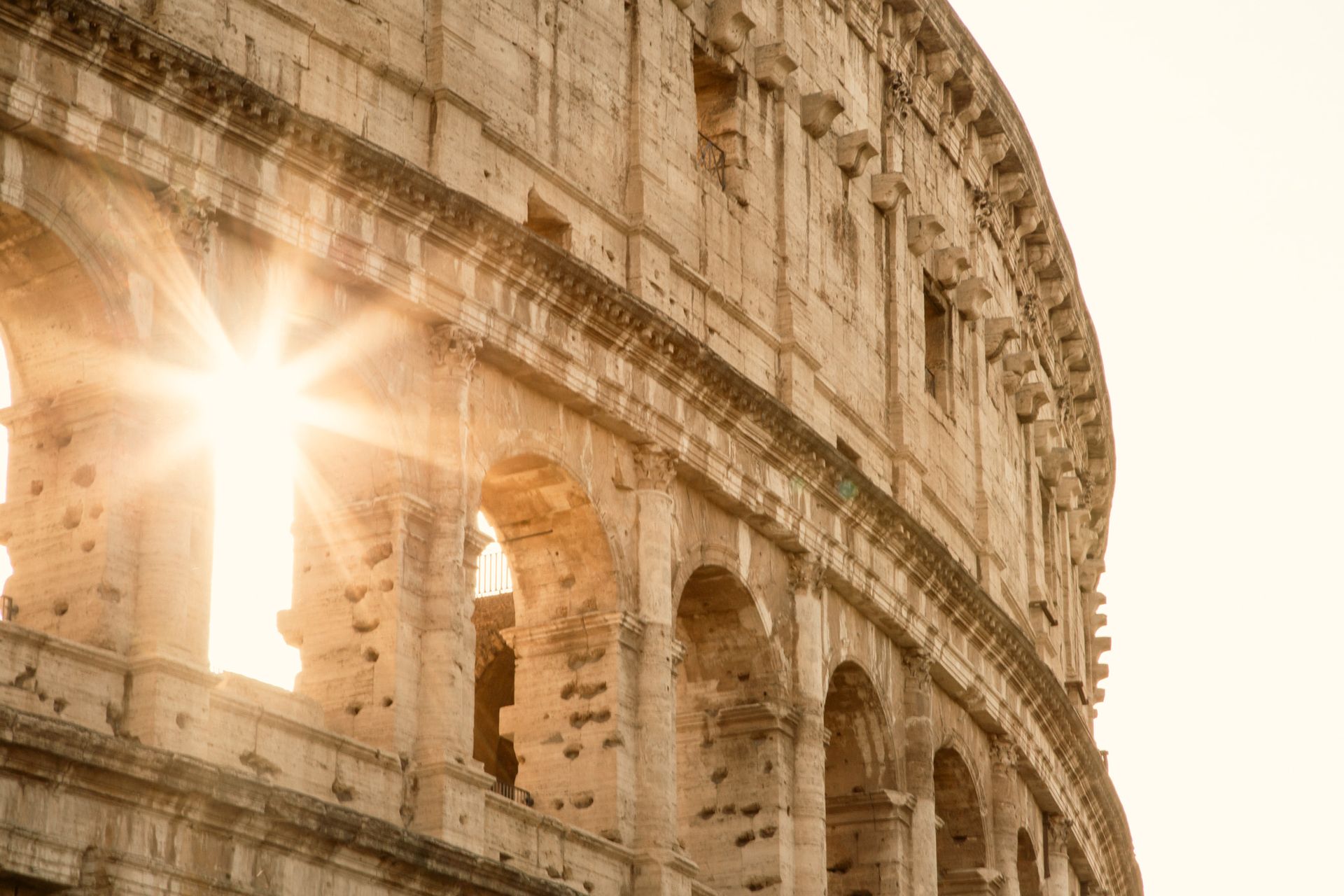 Cityscape of Rome, Italy, with historic buildings, domes, and warm sunlight.