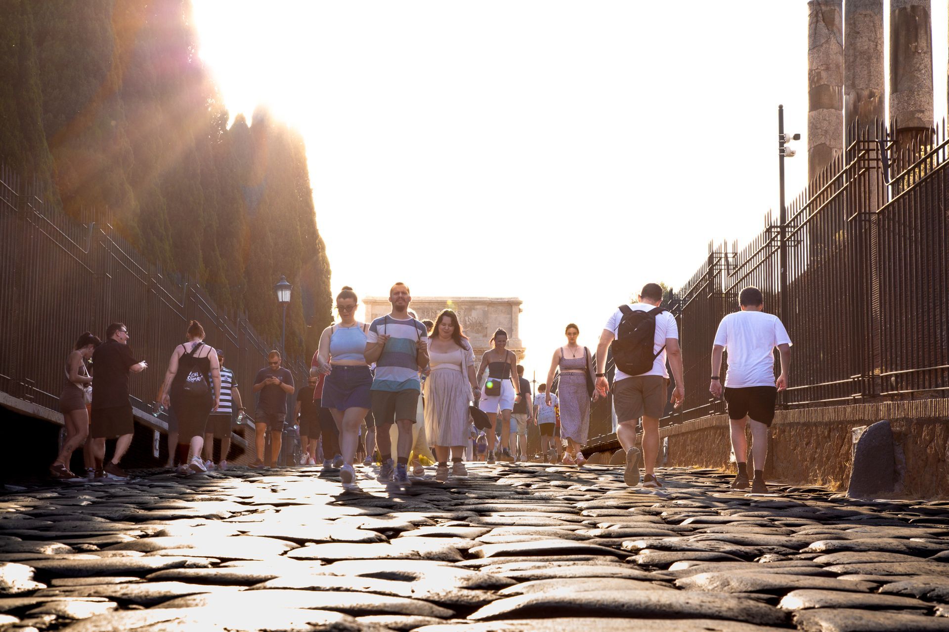 Ruins of the Roman Forum in Rome, Italy, with columns, arches, and buildings against a blue sky.
