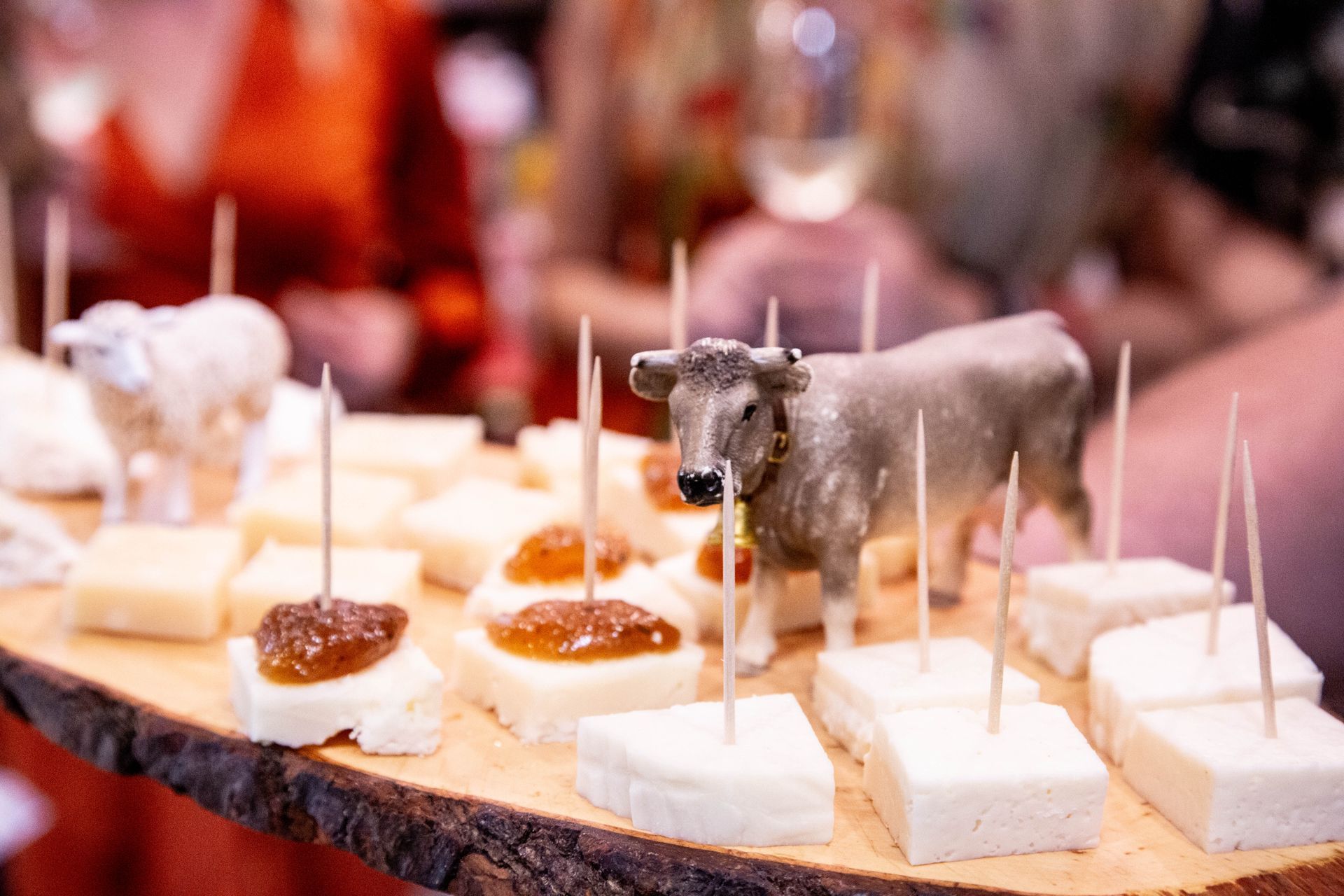 Man slicing roasted pork, likely in a restaurant. He has tattoos and focused expression, holds large knife.