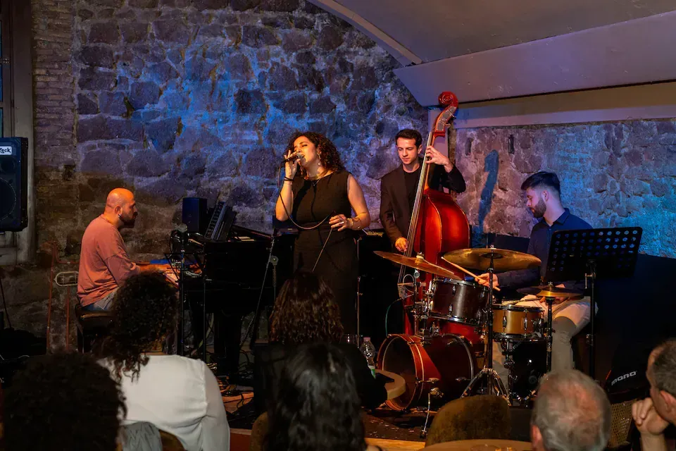 Woman with yellow backpack takes photo of Arch of Constantine, Rome.
