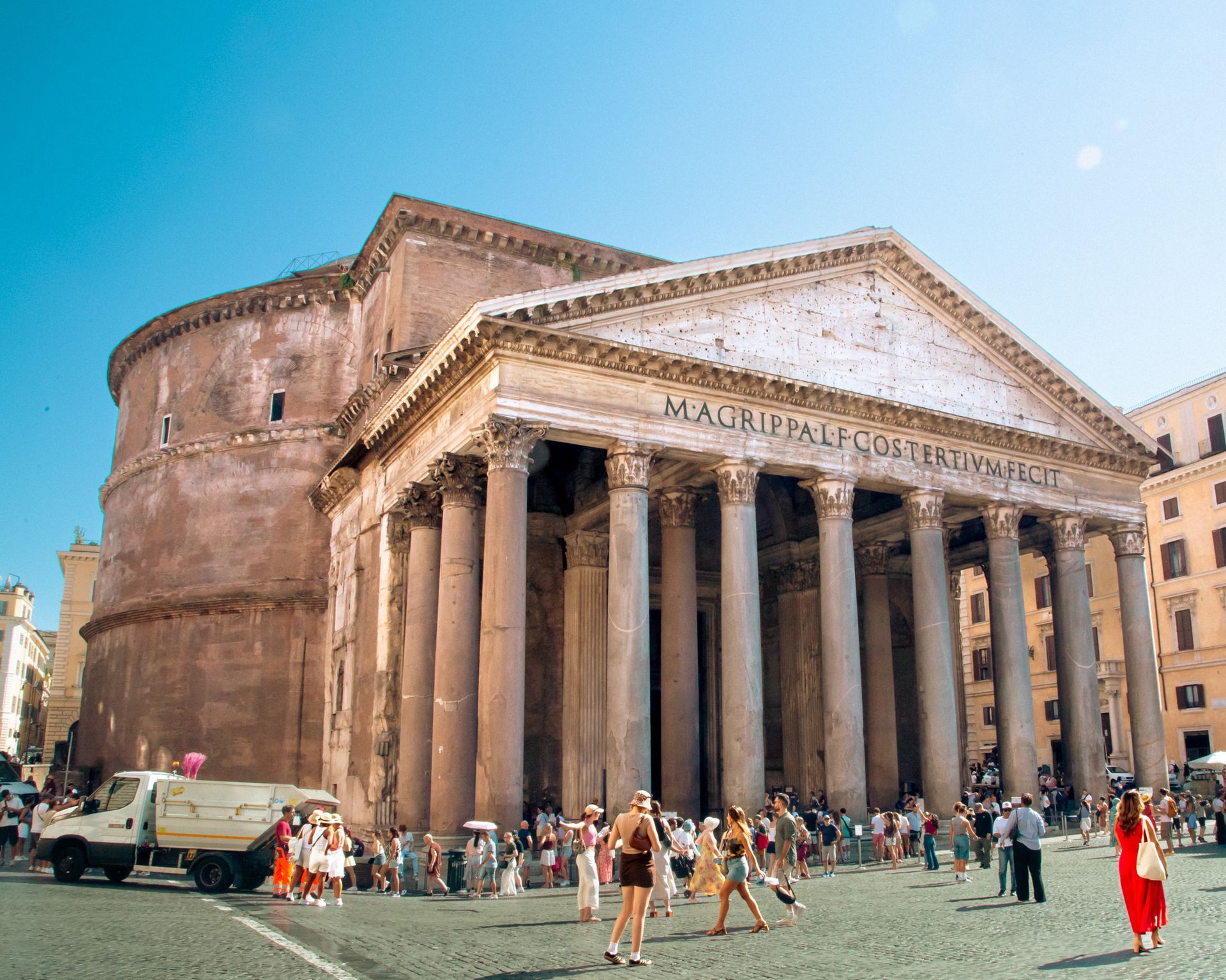 Piazza Navona in Rome with the Fountain of Four Rivers in foreground. Buildings and an obelisk in the background.