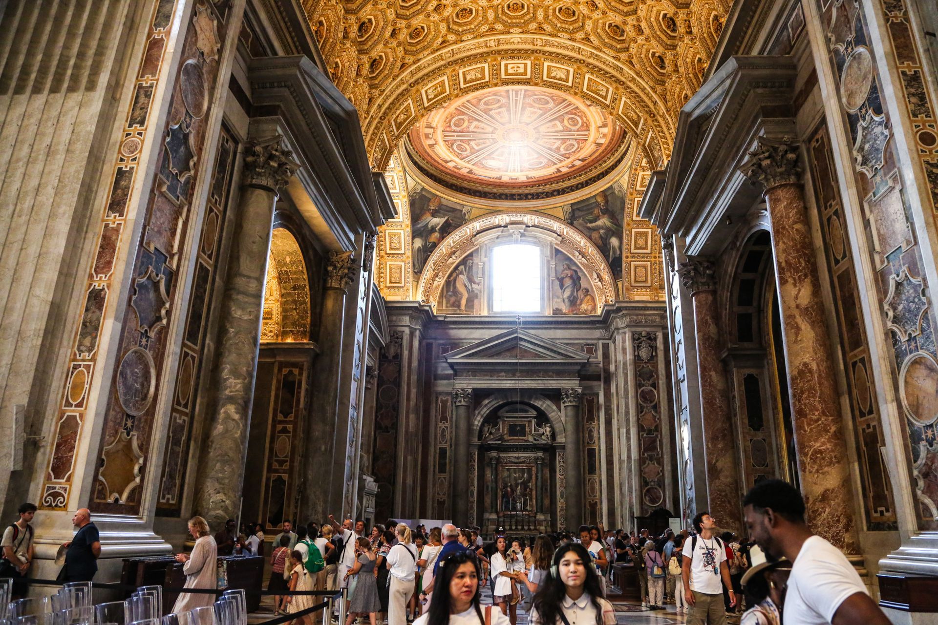 Cityscape of Rome, Italy, with historic buildings, domes, and warm sunlight.