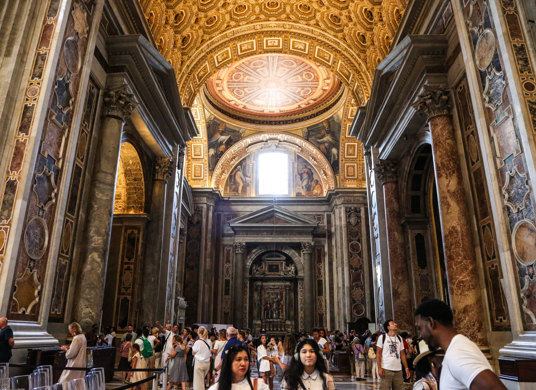 Cityscape of Rome, Italy, with historic buildings, domes, and warm sunlight.