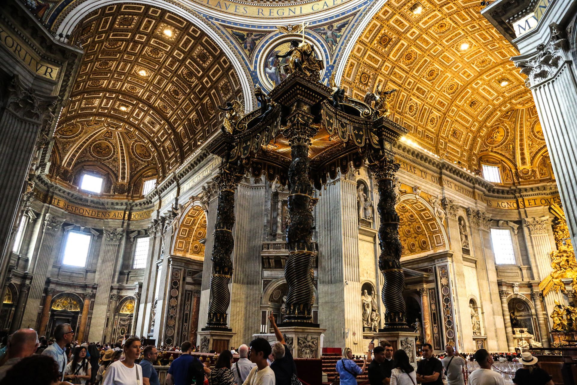 St. Peter's Basilica in Vatican City, seen from afar, with its iconic dome and framed by trees.