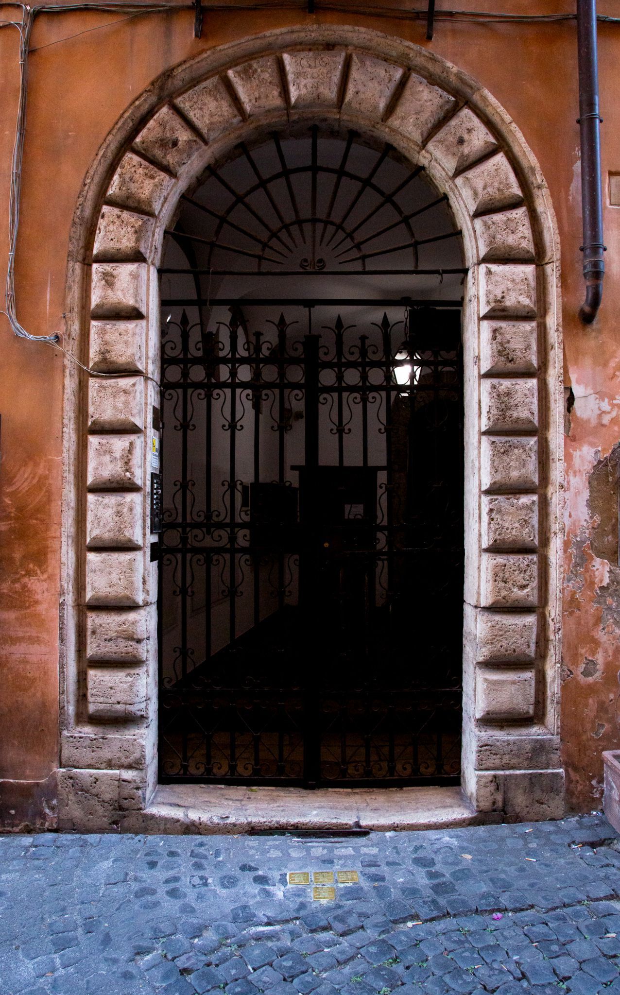 Ancient Roman theater ruins in Rome, Italy, with arched structures and partial columns under a cloudy sky.