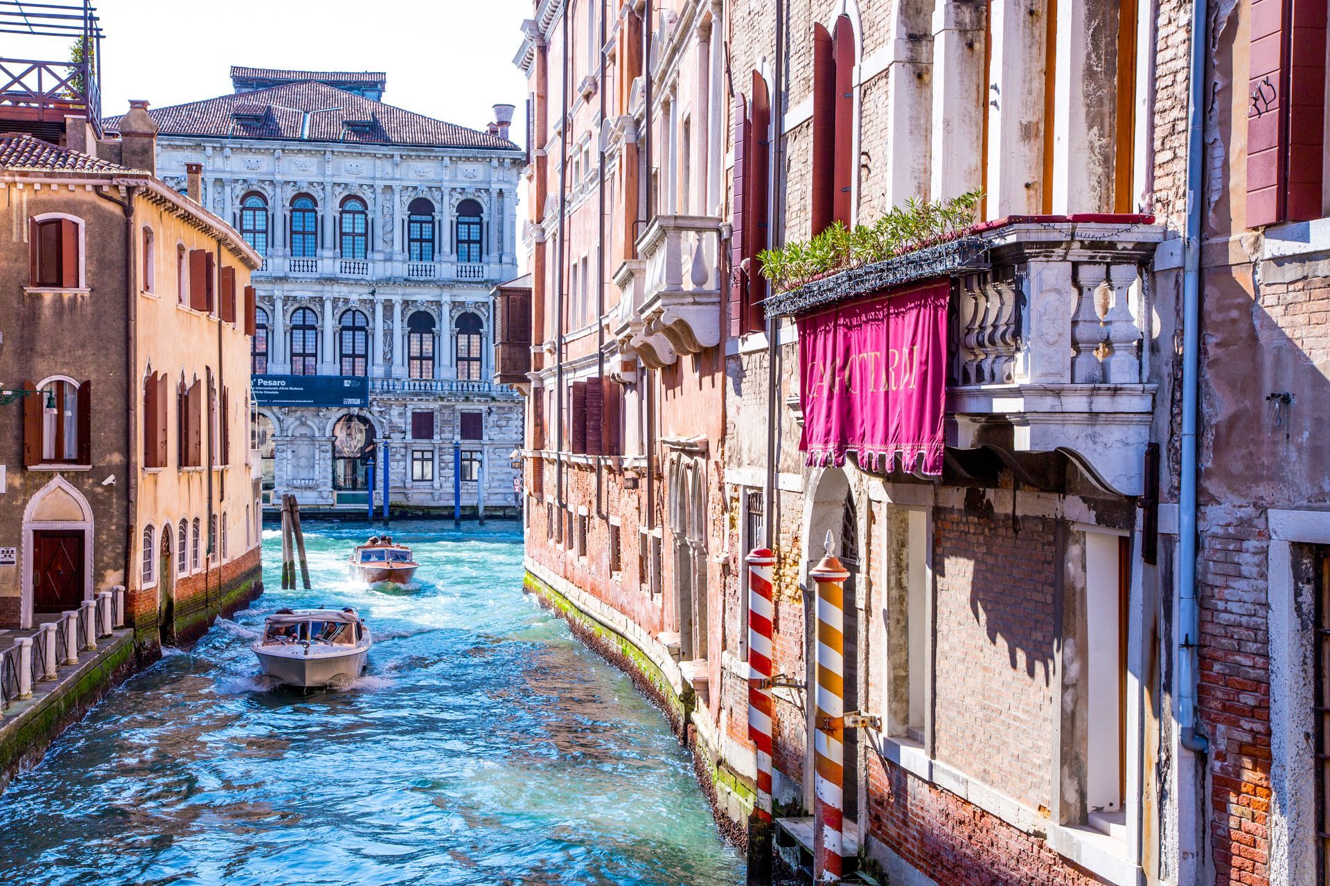 Cityscape of Venice, Italy canals with people on boats.