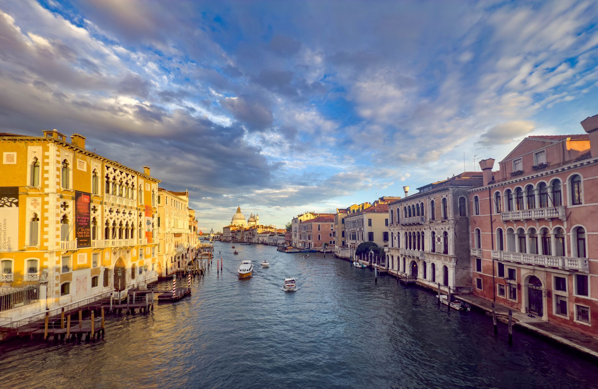 Ruins and buildings in Rome with a prominent domed structure under a blue sky.
