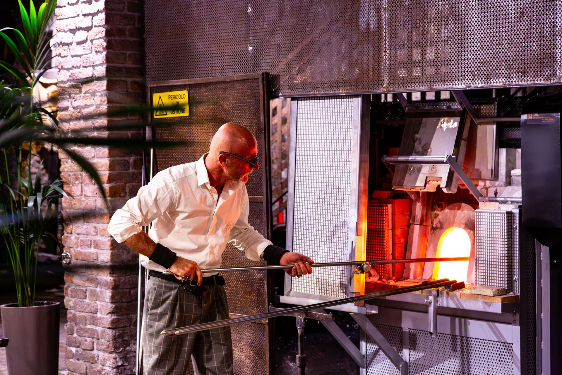 Glass blower working in a furnace on the island of Murano near Venice.