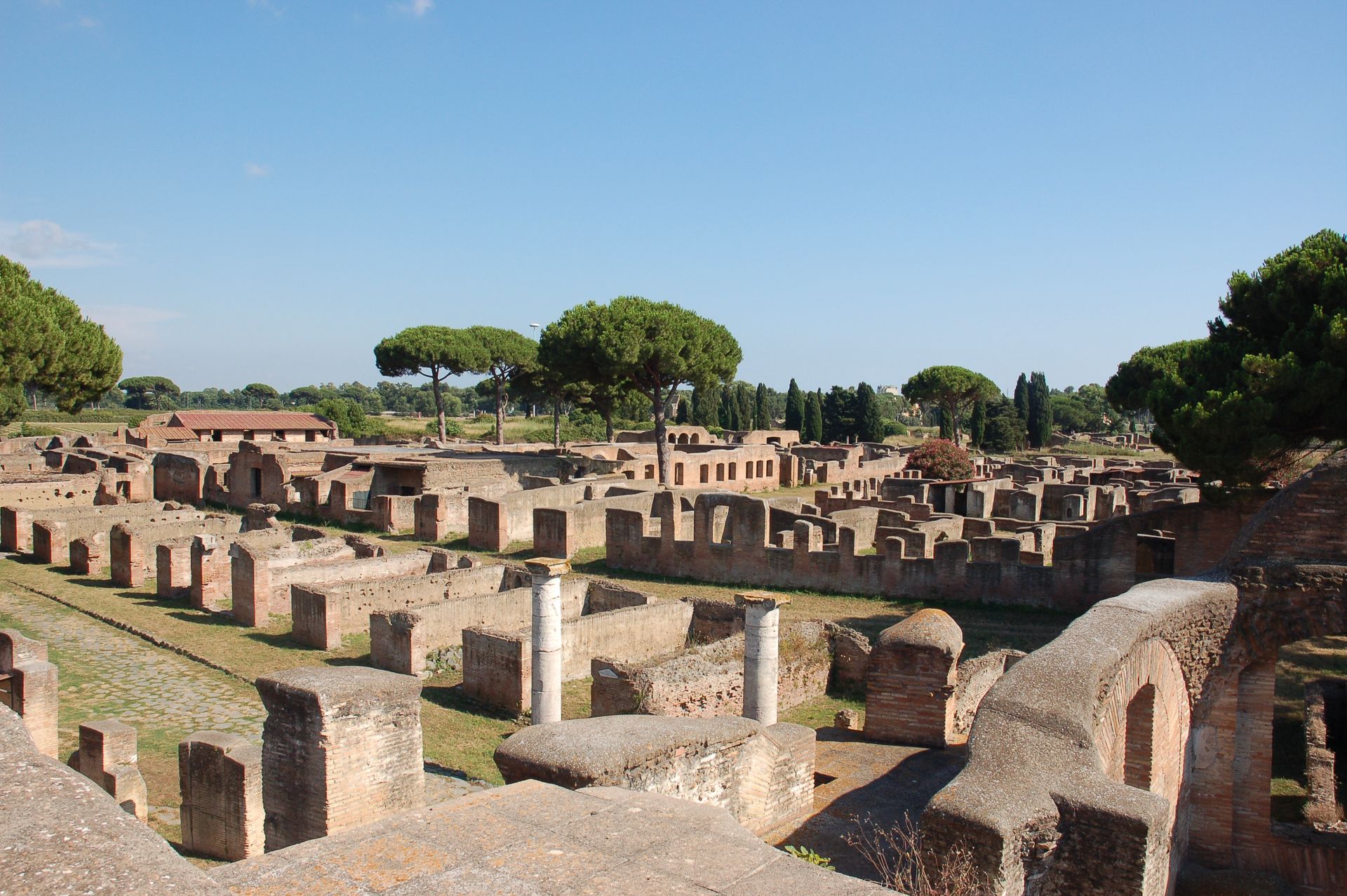 Ruins of Ostia Antica, Italy, showcasing ancient brick walls and buildings under a clear blue sky.