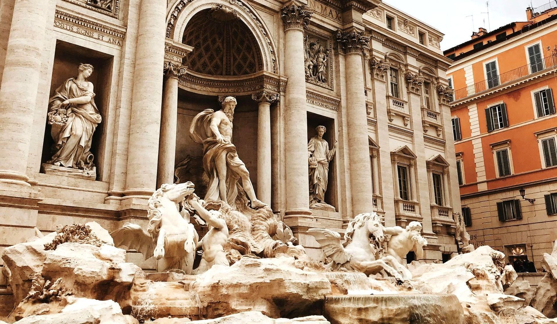 Trevi Fountain in Rome: Baroque architecture with sculptures, water cascading, beige and brown tones.