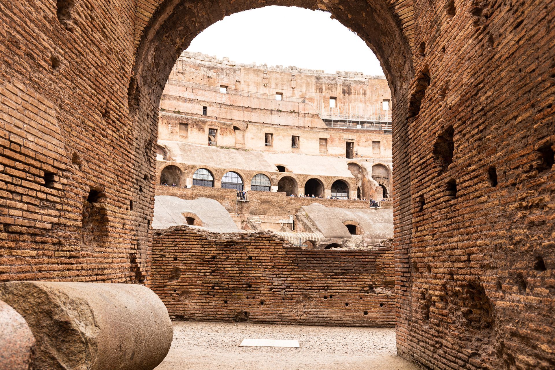View through an archway into the Colosseum, Rome. Brick walls and arches.