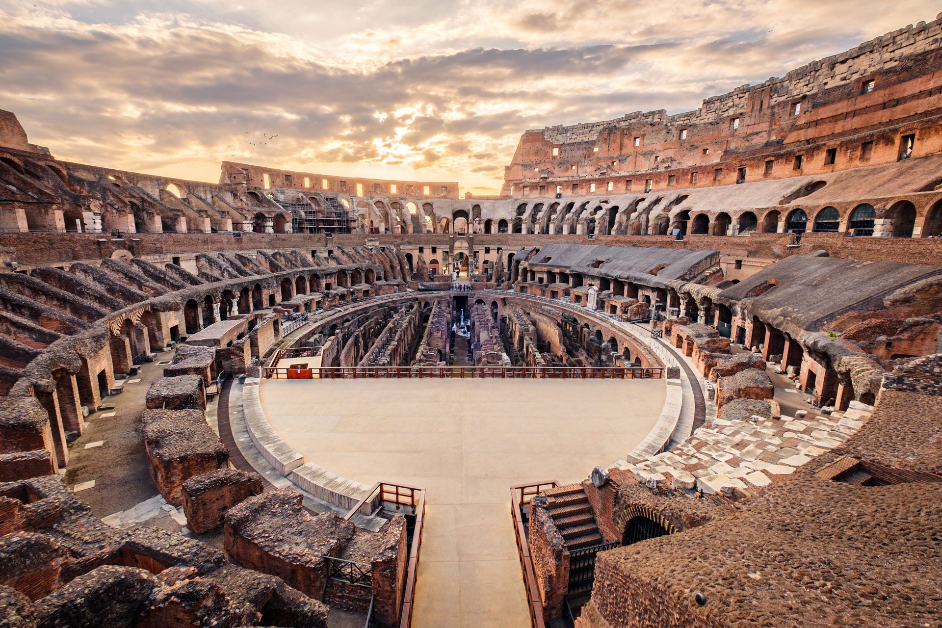 Ruins and buildings in Rome with a prominent domed structure under a blue sky.