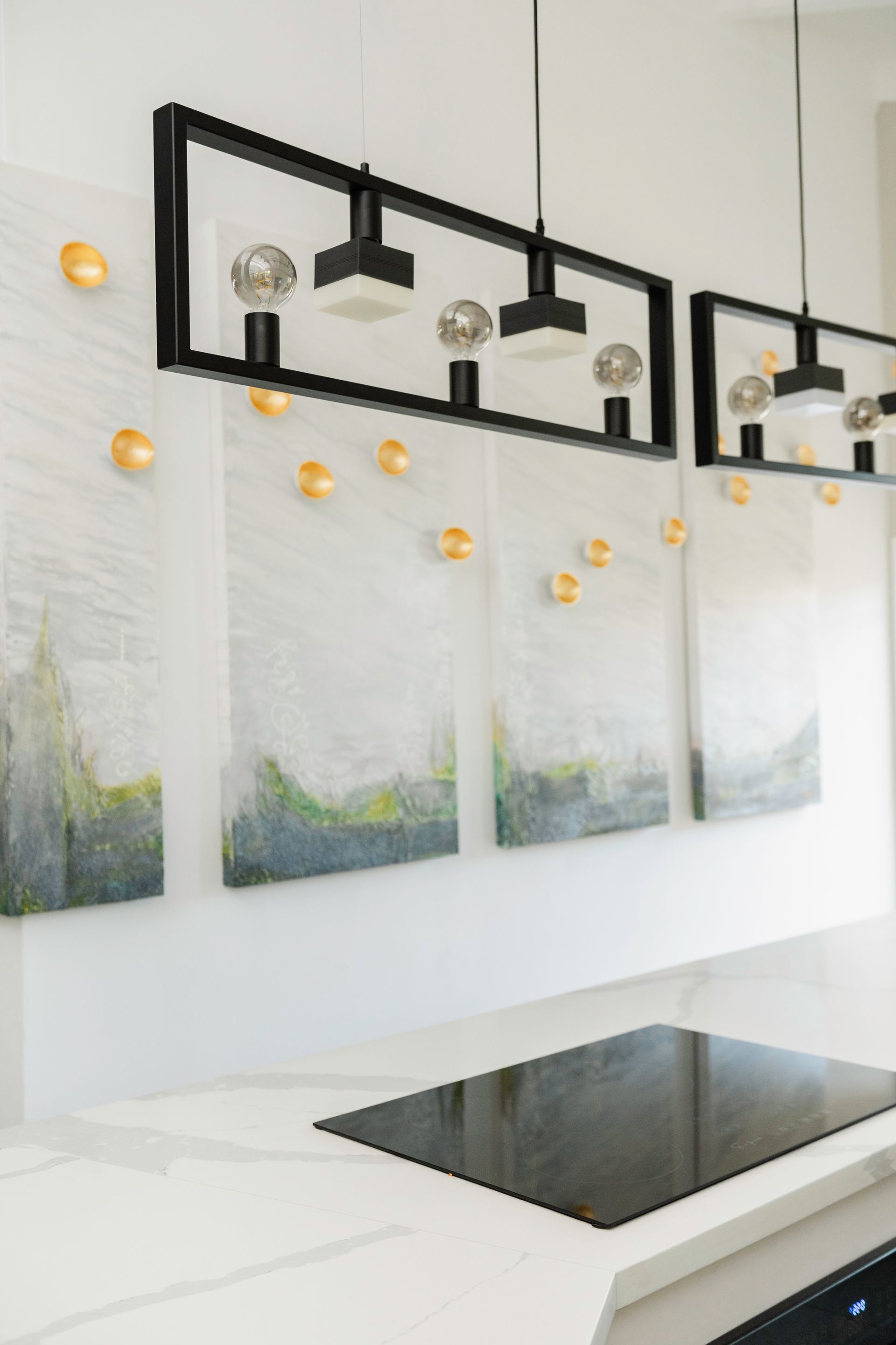 A kitchen with a stove top oven and paintings on the wall.