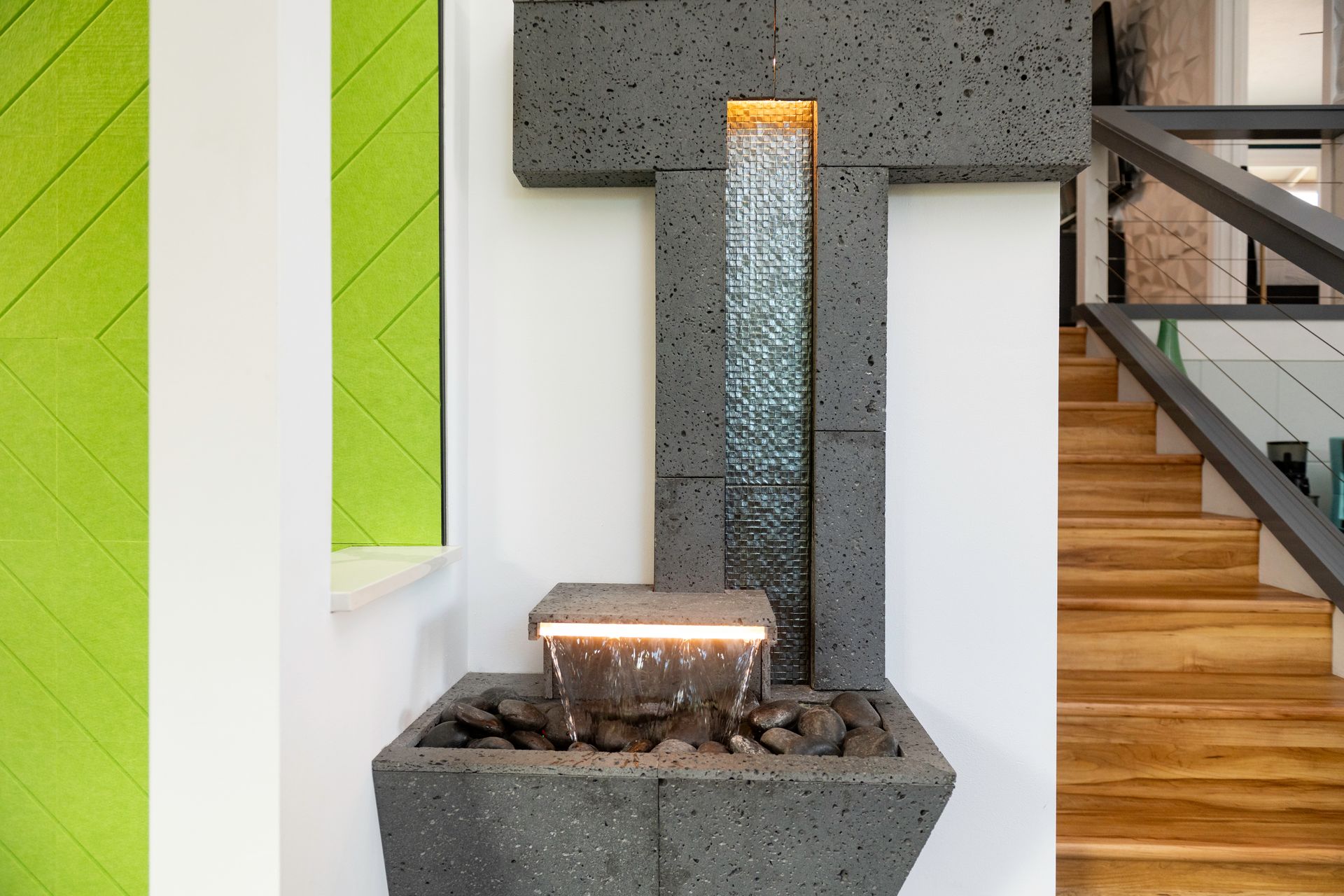 A water fountain in a room with stairs in the background