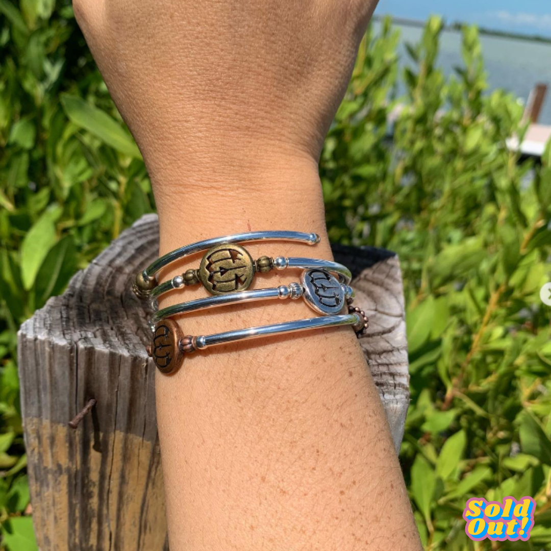 A person is wearing three bracelets on their wrist.