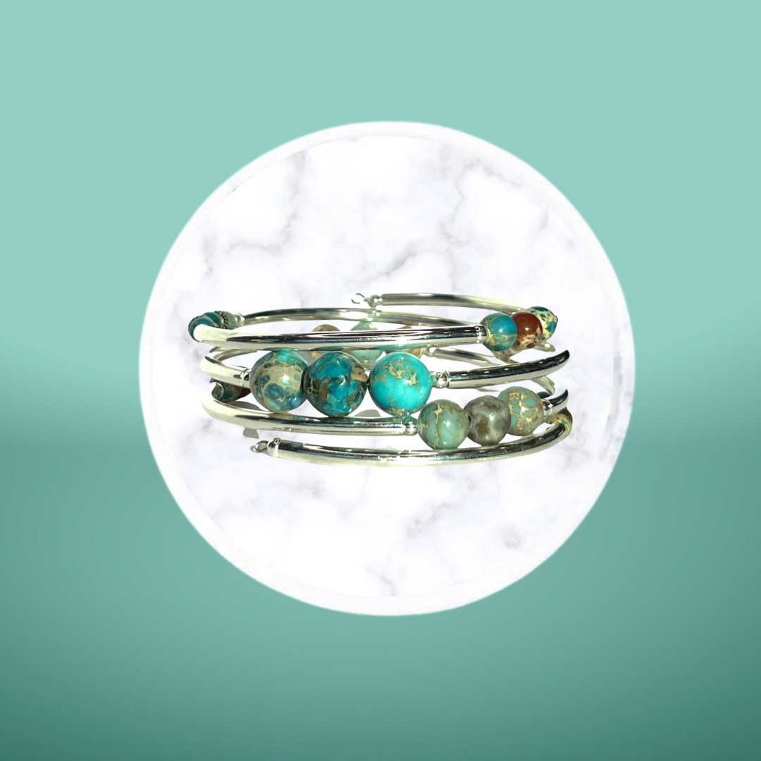 A silver ring with turquoise beads is stacked on top of each other.