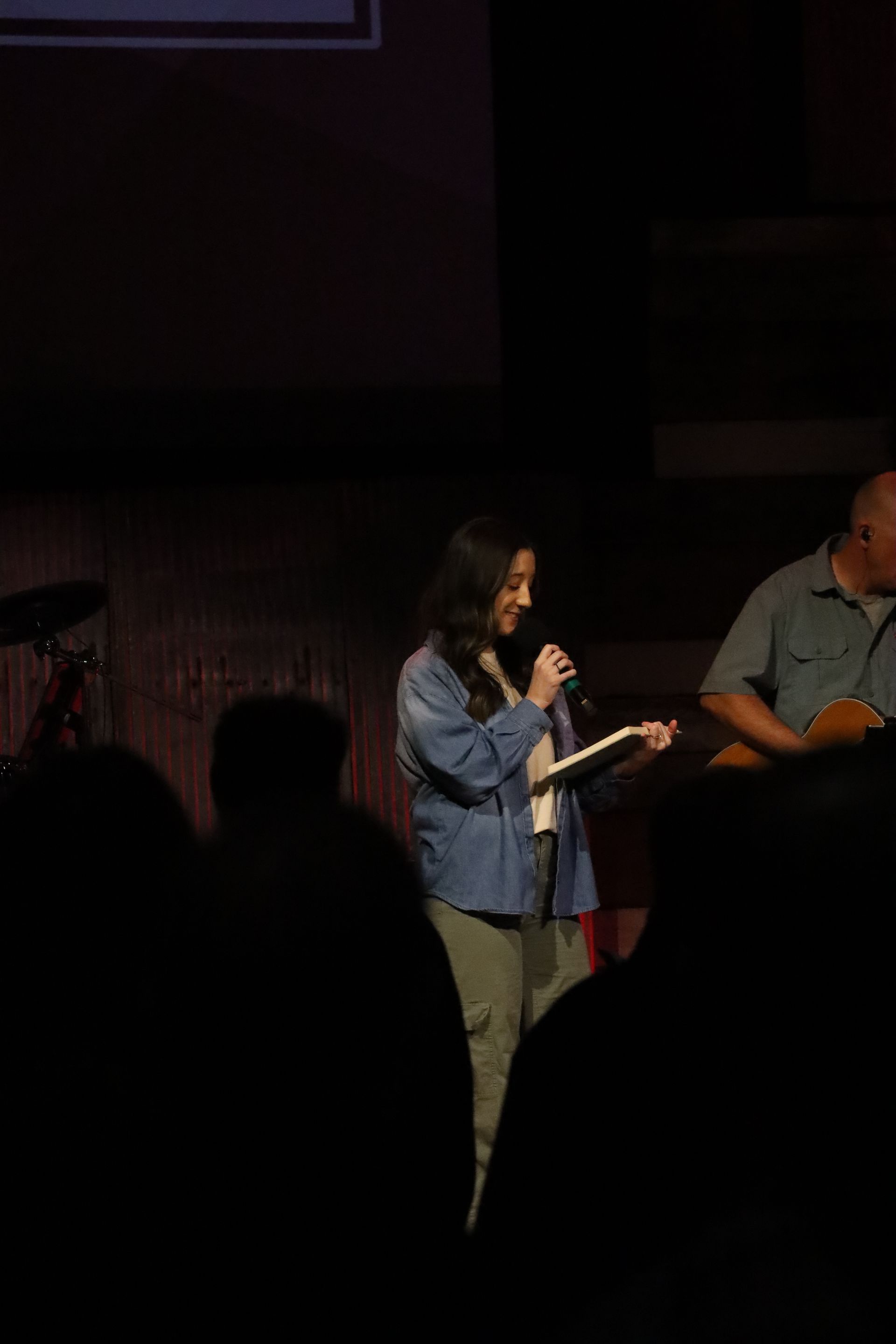 a man and a woman are singing into microphones on a stage .