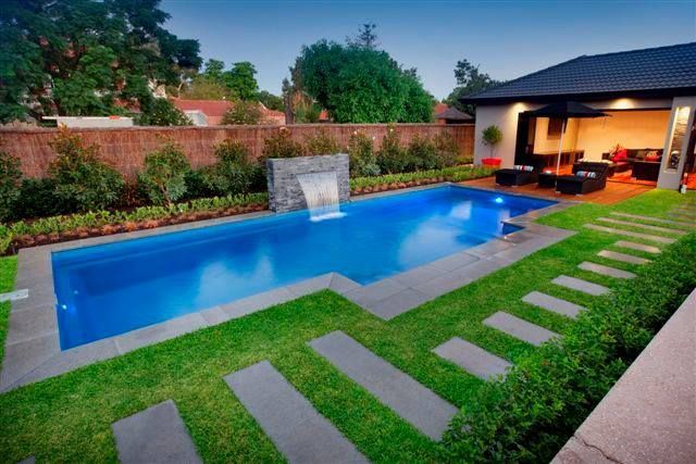 A large swimming pool in the backyard of a house
