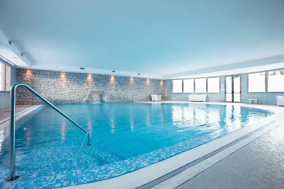 A large indoor swimming pool with a staircase leading to it.