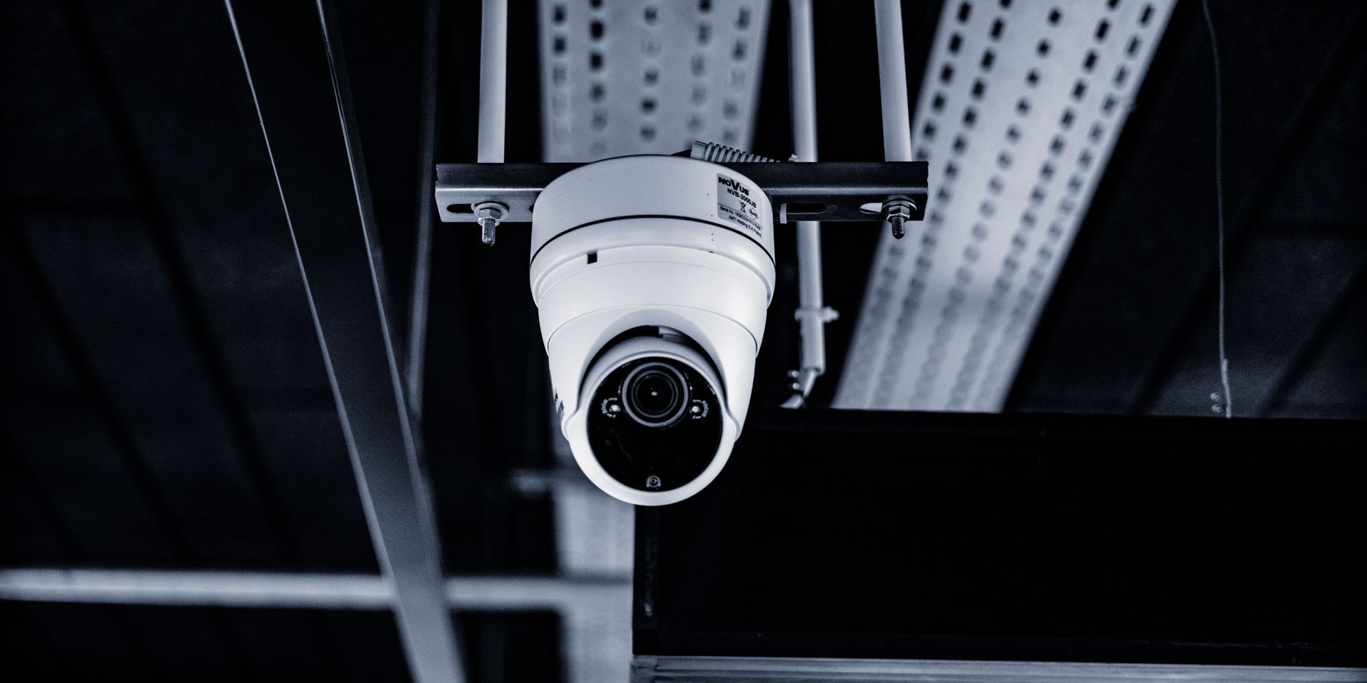 Security camera mounted on a ceiling, pointing downward.