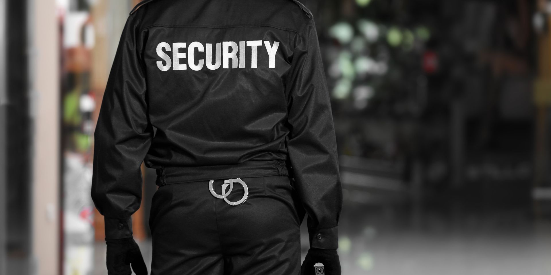A security guard in a black uniform with