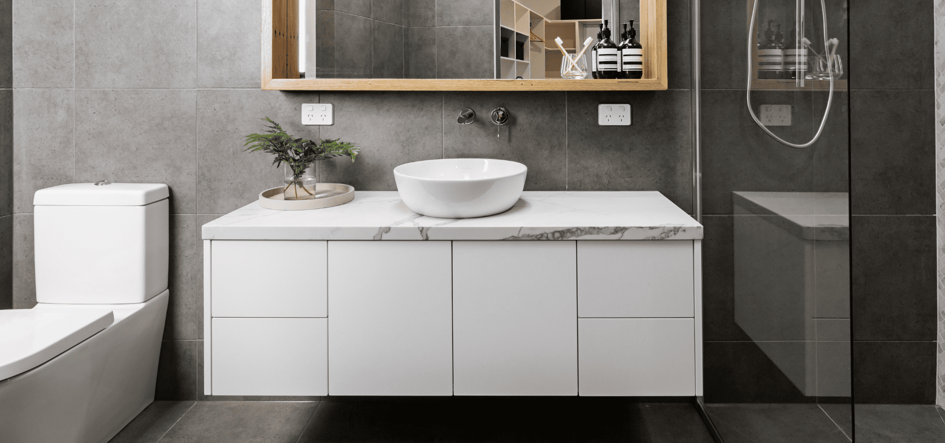 Vanity with stone countertop in a sleek, minimalist black bathroom