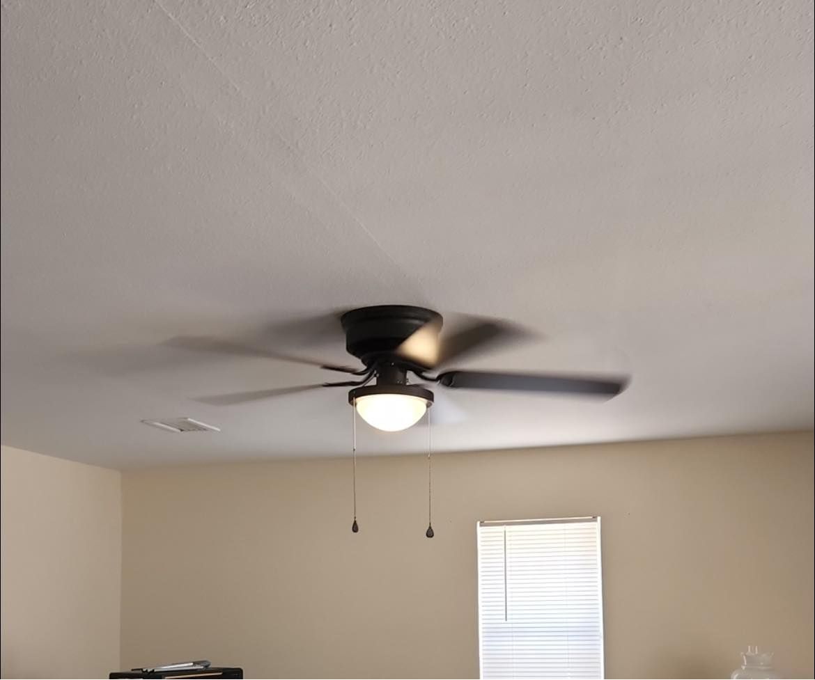 A living room with a ceiling fan and a window