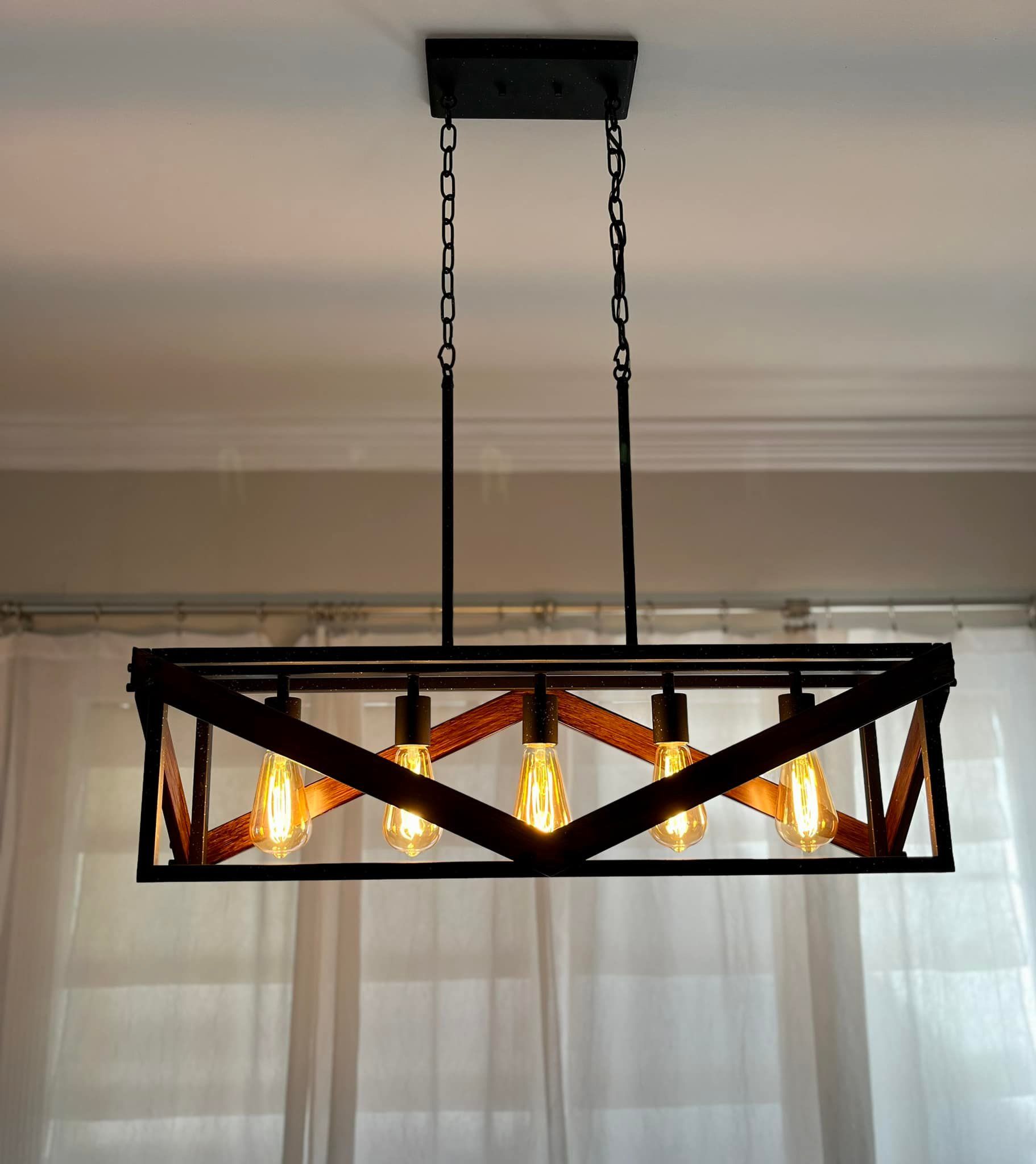 A chandelier is hanging from the ceiling in front of a window