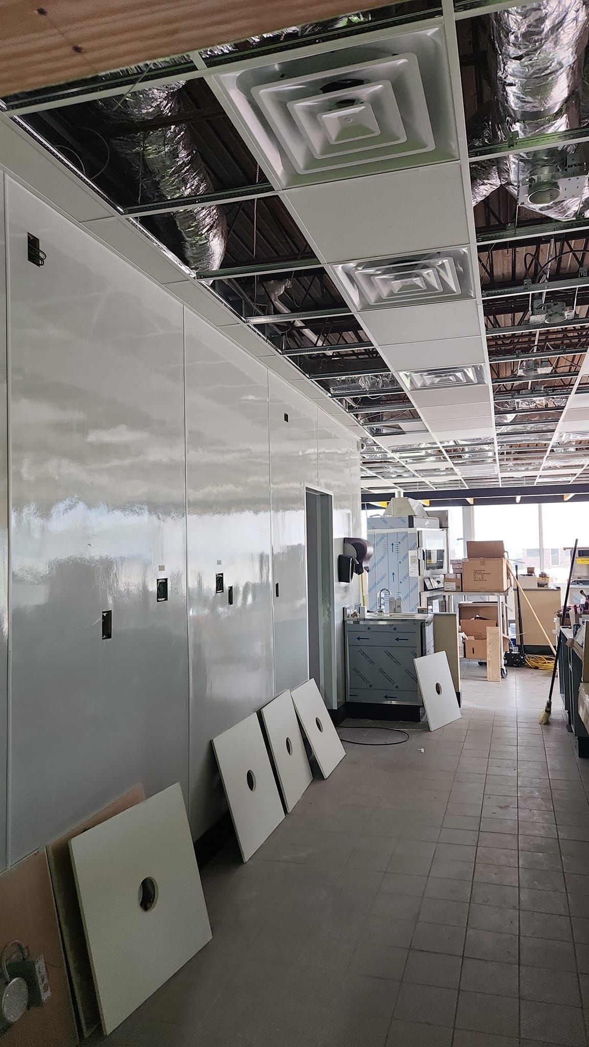 A room with a ceiling that is being remodeled and a lot of boxes on the floor.