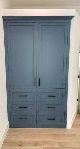 A blue cabinet with drawers and doors in a room.