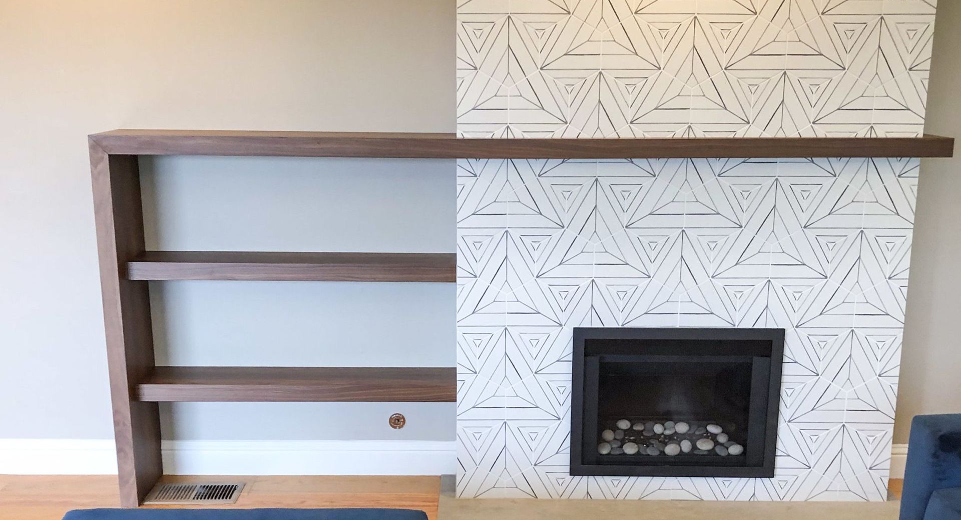 A living room with a fireplace and shelves.