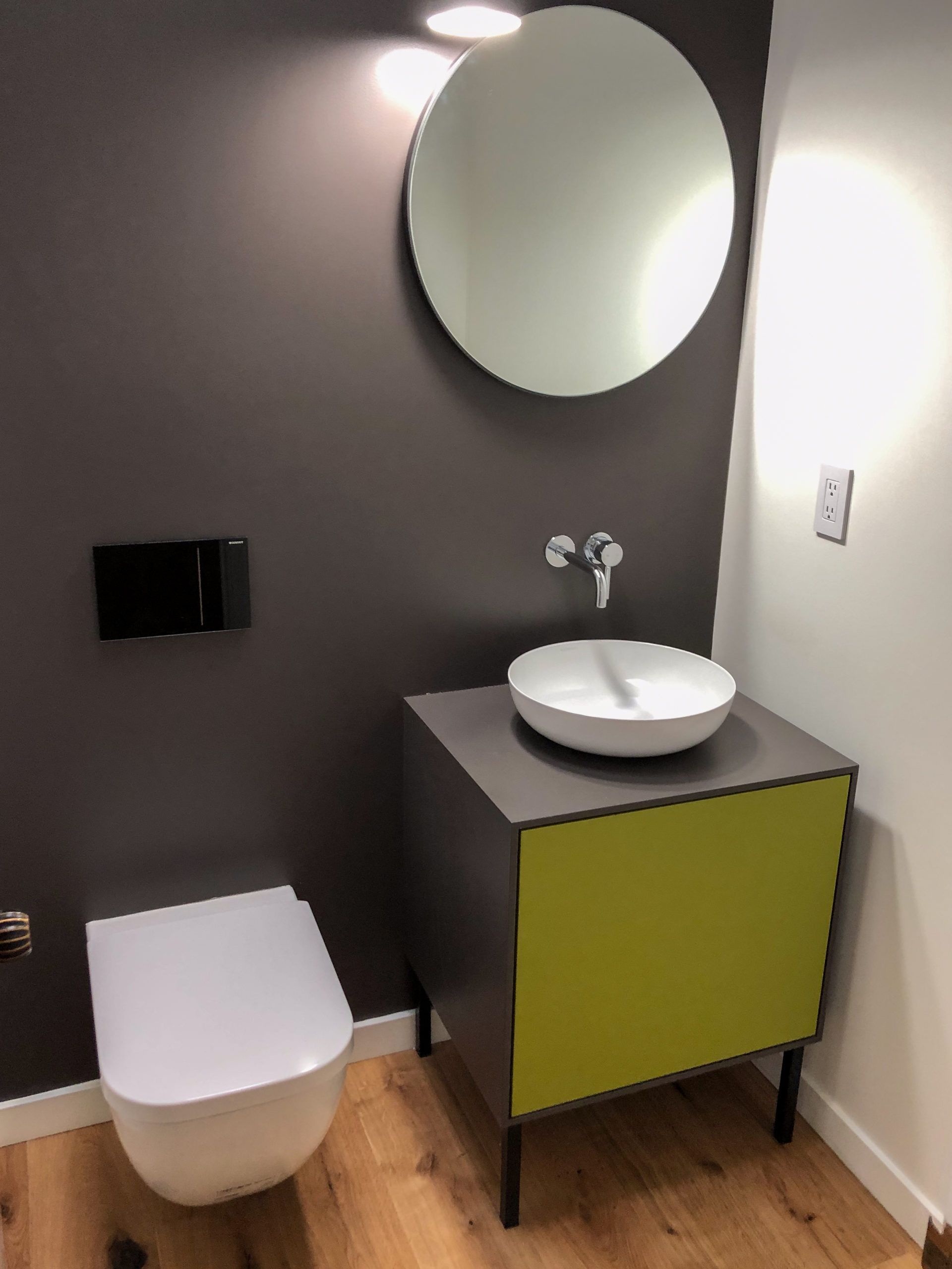 A bathroom with a toilet a sink and a mirror