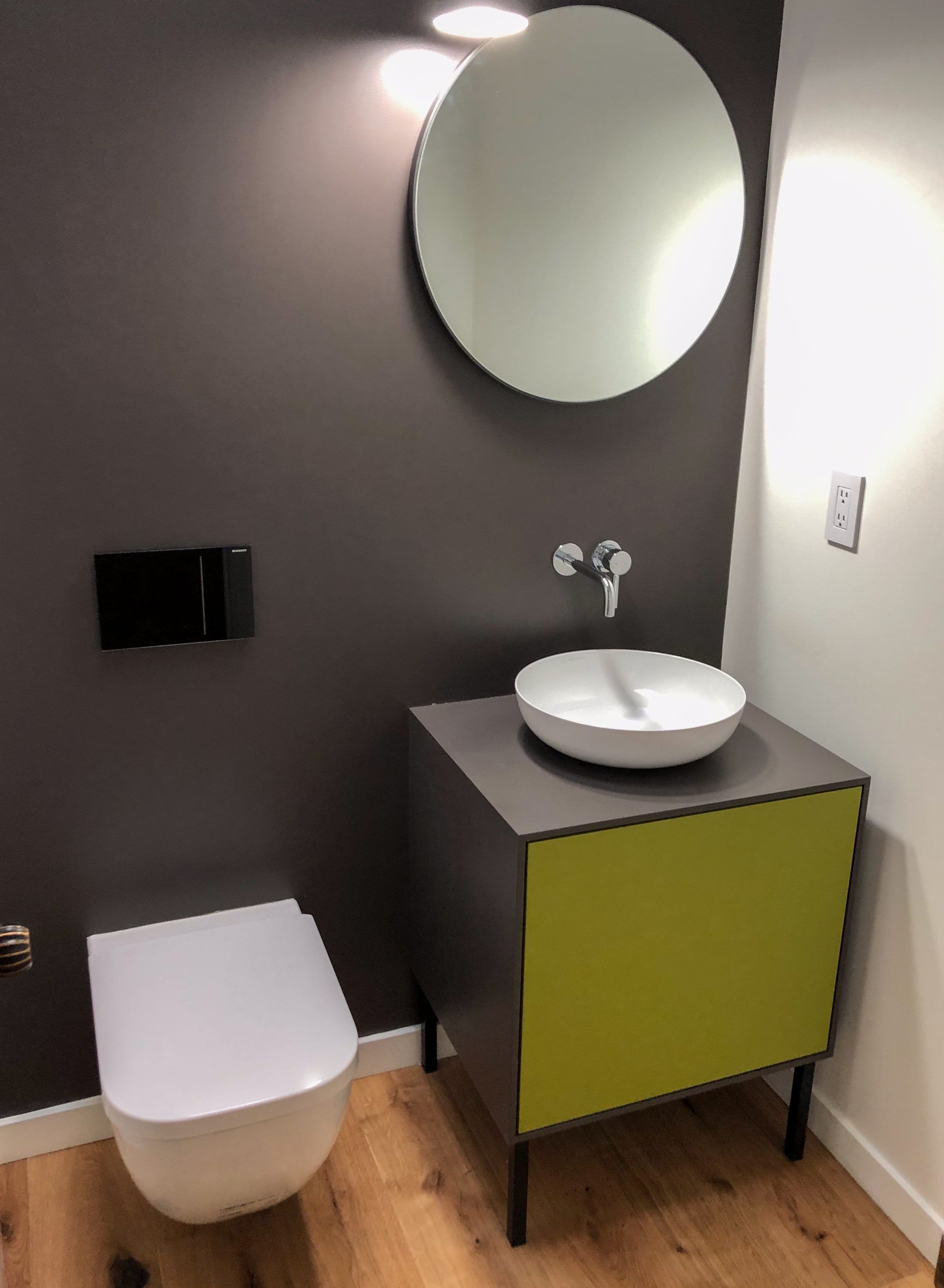 A bathroom with a toilet a sink and a mirror