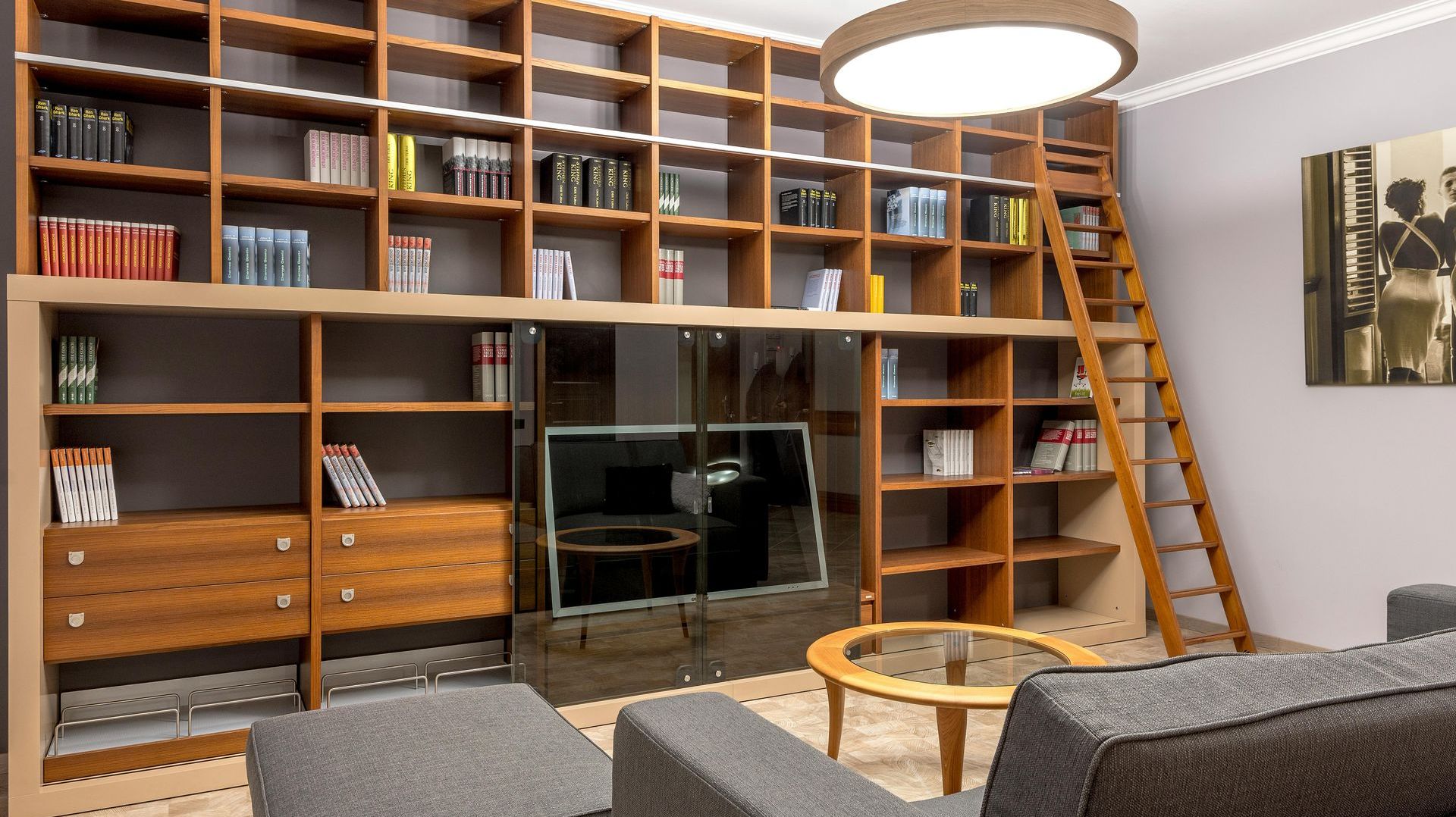 A living room with lots of bookshelves and a ladder