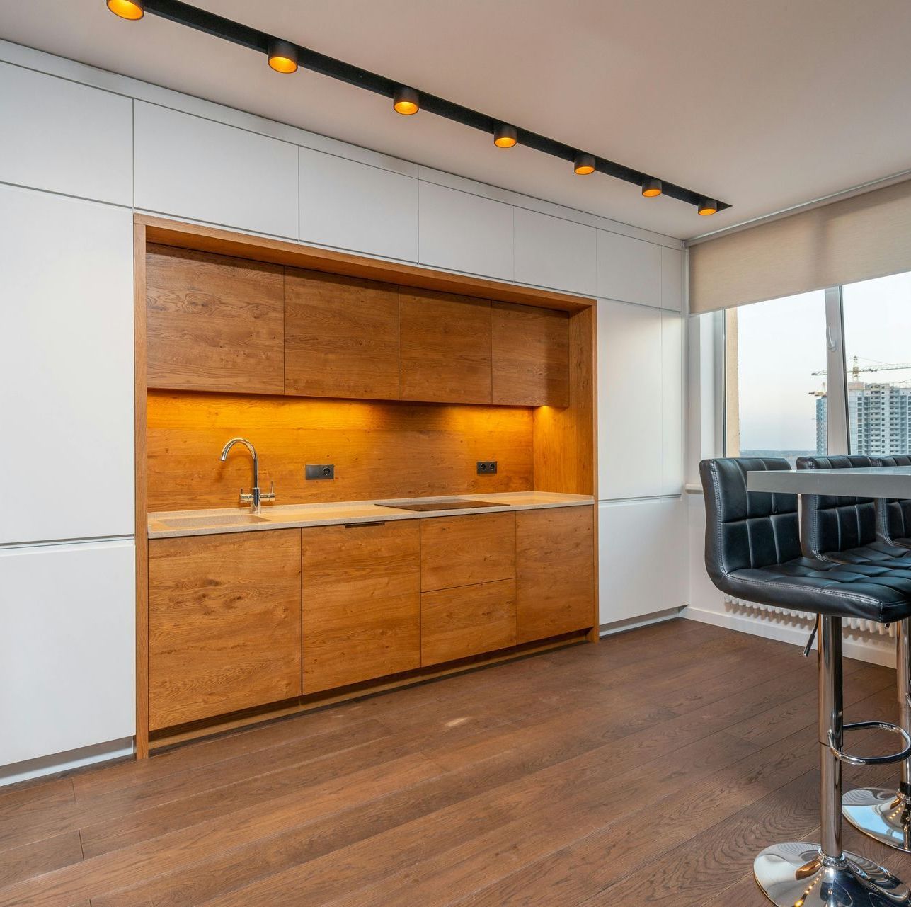 A kitchen with wooden cabinets and white walls