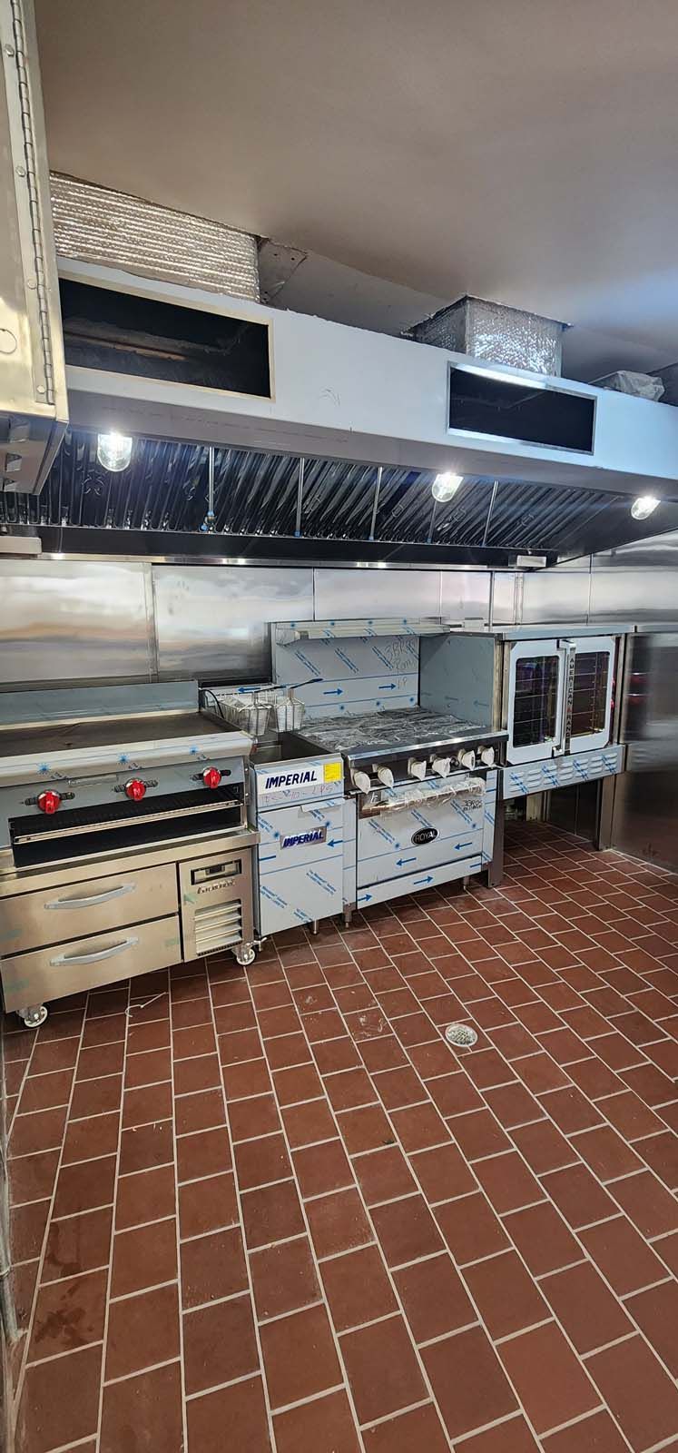 A kitchen with stainless steel appliances and a tiled floor.