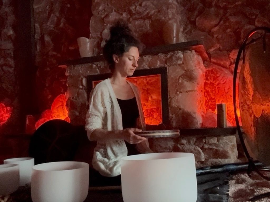 A woman is playing a musical instrument in a cave.