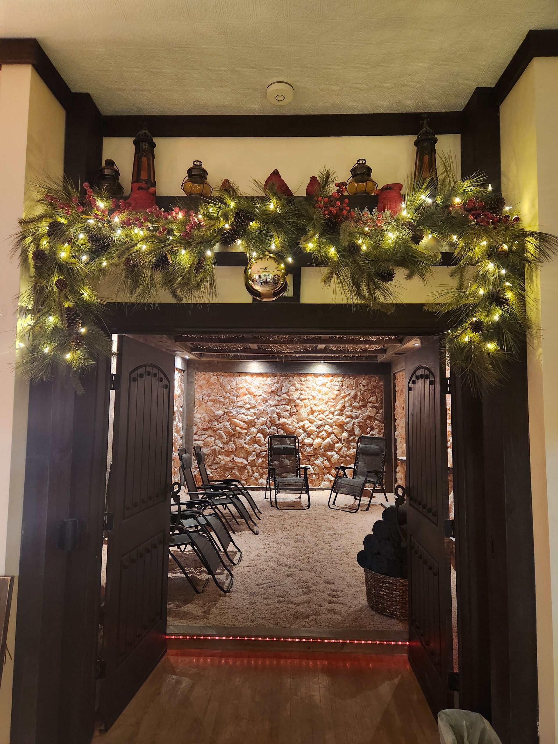 An entryway decorated with Christmas garland and lights.
