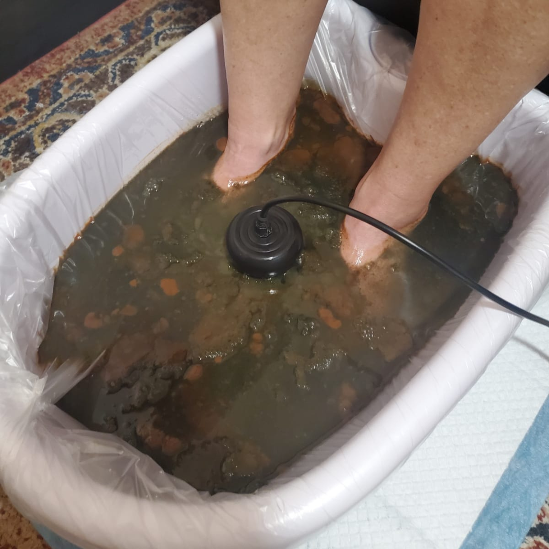 A person is washing their feet in a tub of water