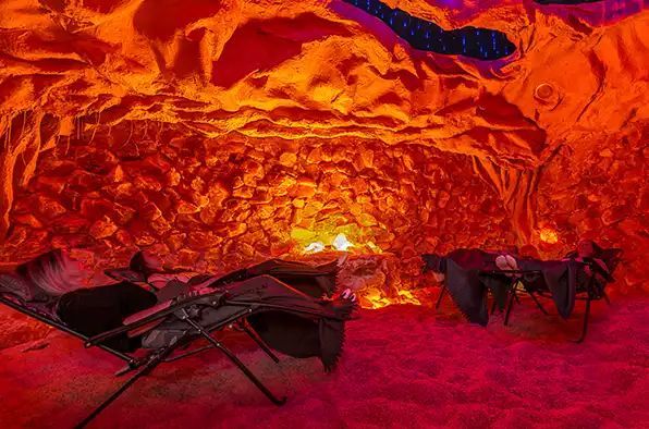 A person is laying in a chair in a cave.