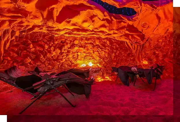A person is laying in a chair in a cave.