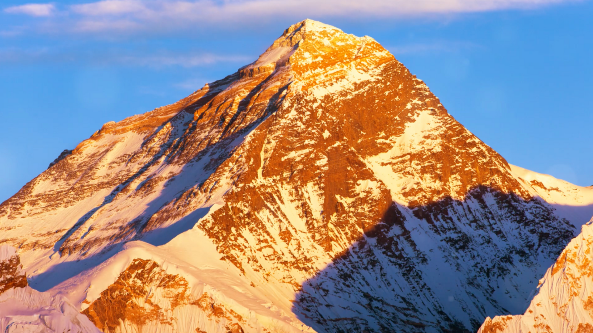 A snowy mountain with a blue sky in the background