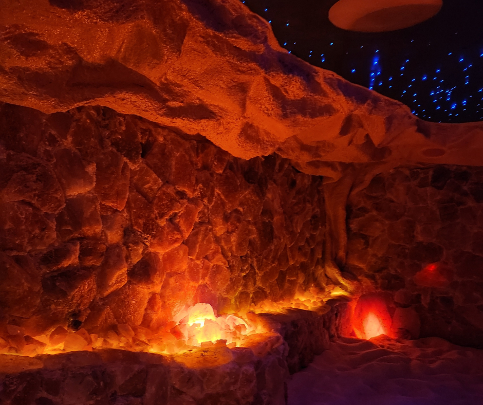 Cave-like space with orange and red lighting on textured walls. Blue 