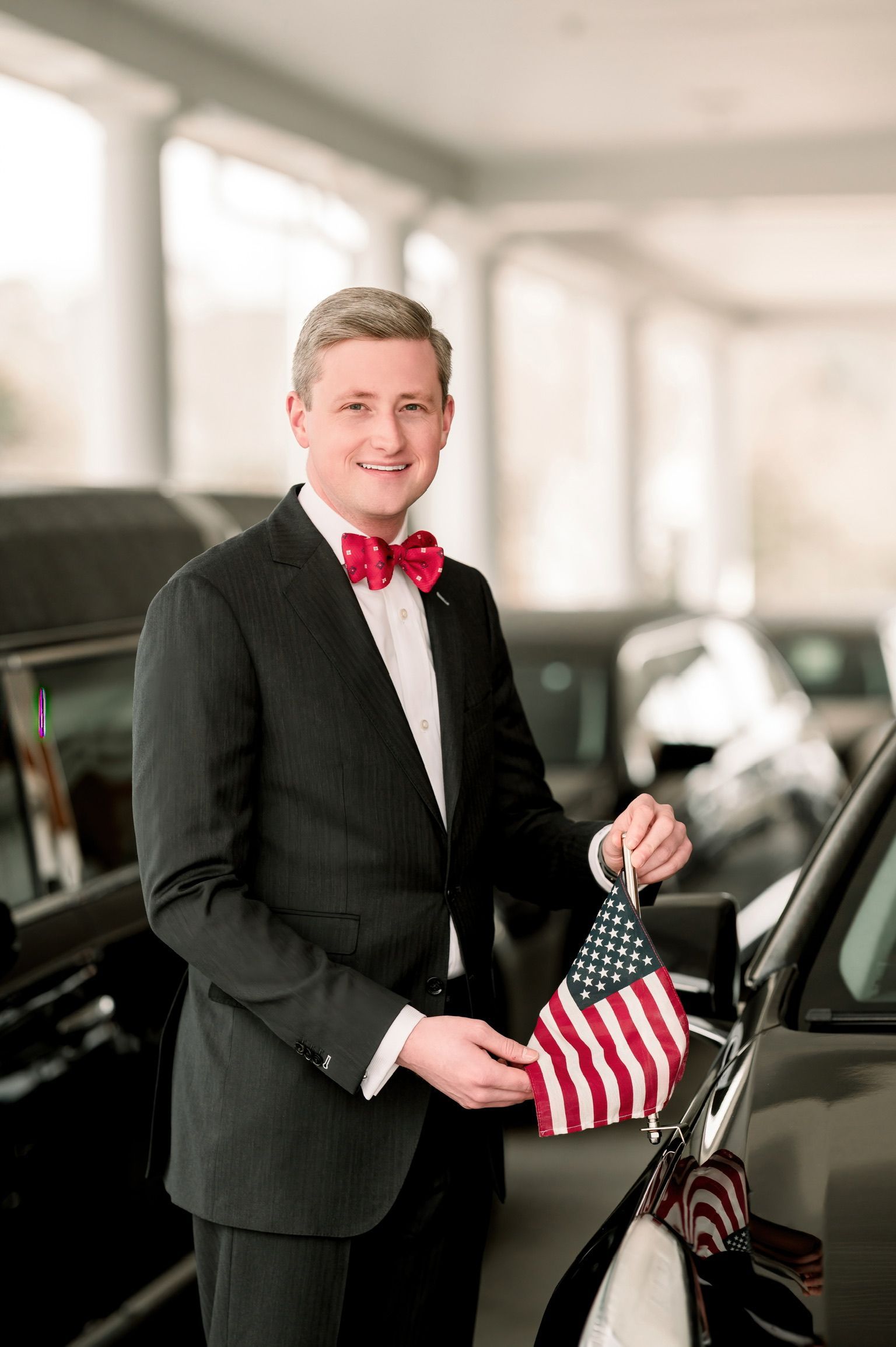 A man in a military uniform salutes in front of a cemetery