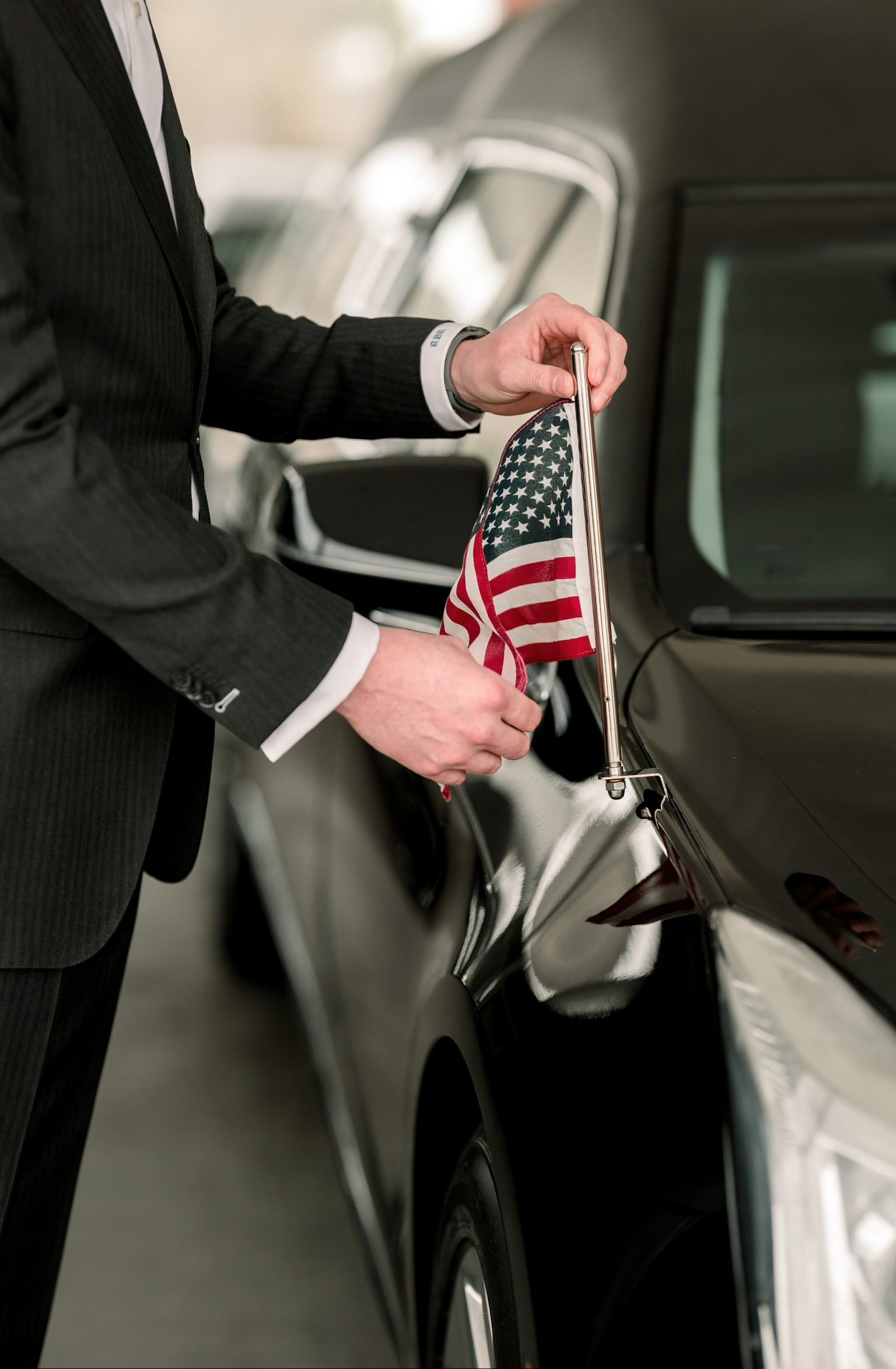 A group of people are standing around a coffin at a funeral.