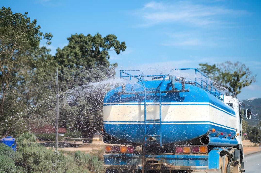 Blue and White Water Truck is Spraying Water — L&V Civil Contracting in Park Ridge, QLD