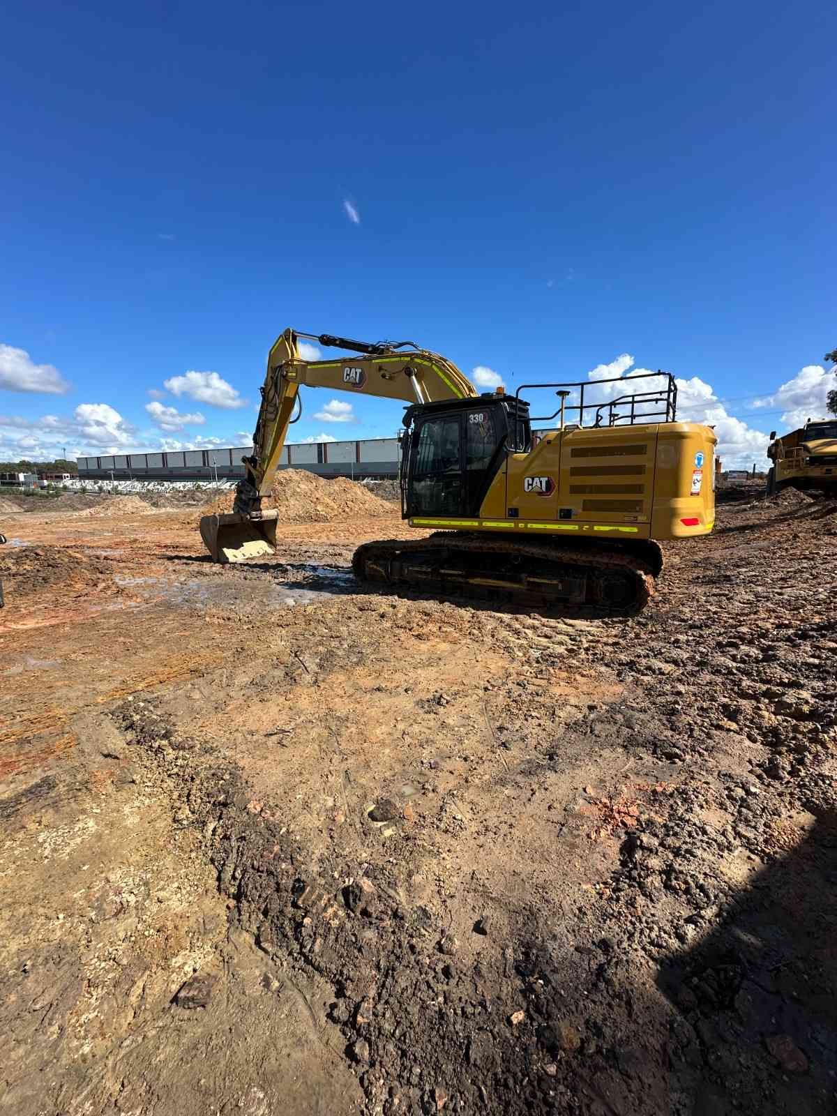 A Yellow Excavator Is Sitting on Top of A Dirt Field — L&V Civil Contracting in Park Ridge, QLD