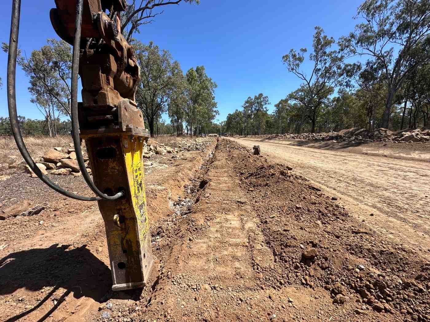 A Yellow Hammer Is Sitting on The Side of A Dirt Road — L&V Civil Contracting in Park Ridge, QLD