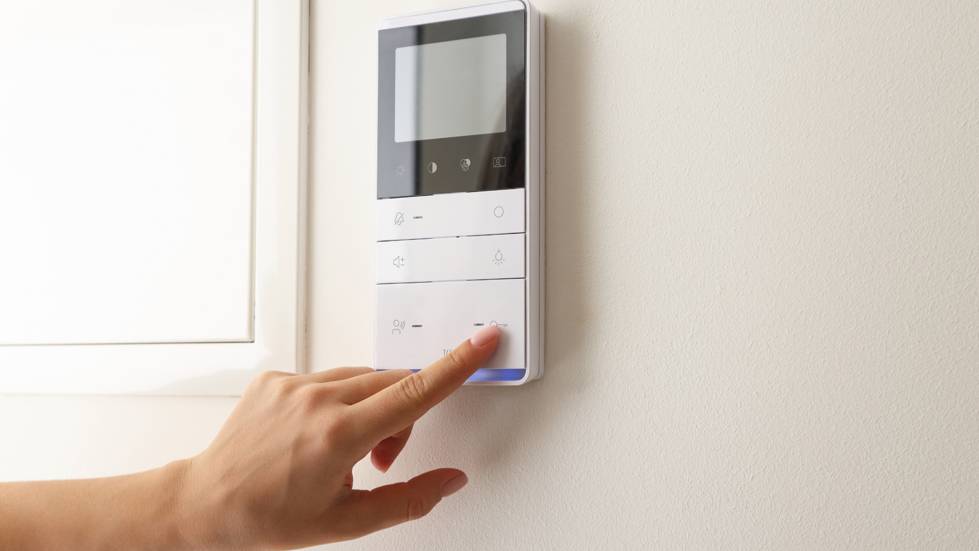 Hands holding a tablet showing an industrial machine interface in a warehouse aisle