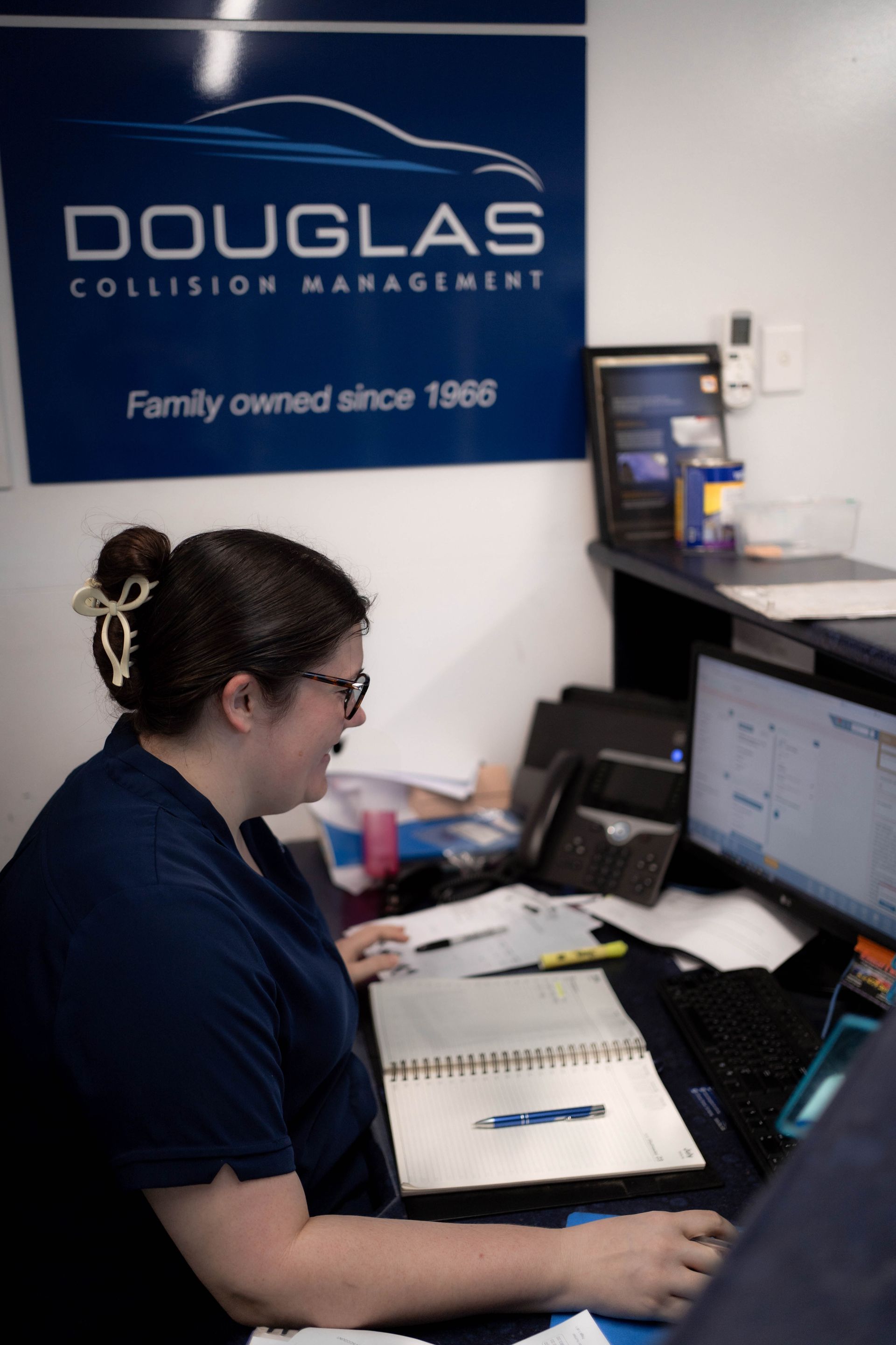 Woman working at a desk in an auto collision repair shop — Douglas Collision Management In Currajong, QLD